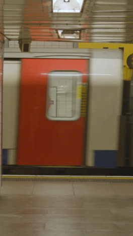 Vertikales-Video-Der-U-Bahn,-Die-Den-Bahnsteig-An-Der-U-Bahnstation-Von-London-King&#39;s-Cross-St.-Pancras-Uk-Verlässt